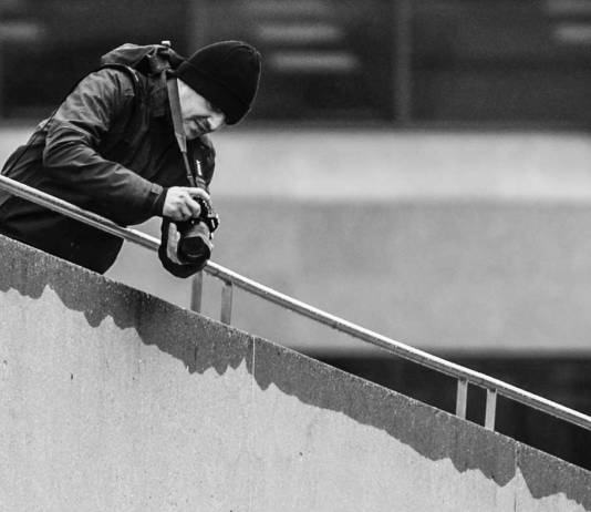 Person shooting video from the top of a staircase.