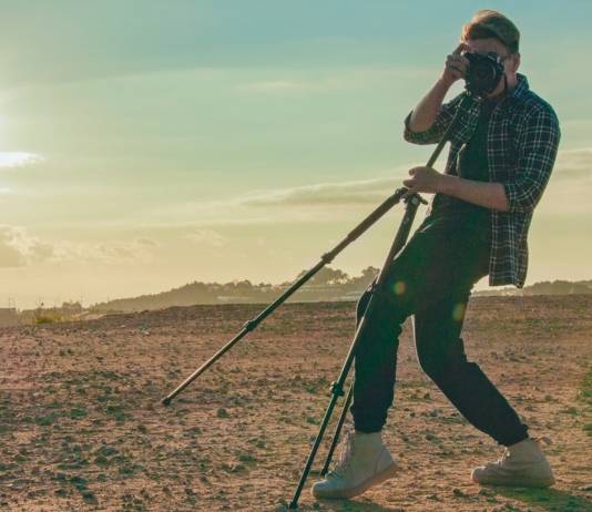 Man posing with a tripod in the desert